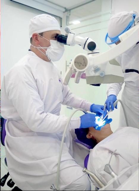 Dr. David Troncoso tallando carillas cerámicas con microscopio clínico en Oral Center El Poblado